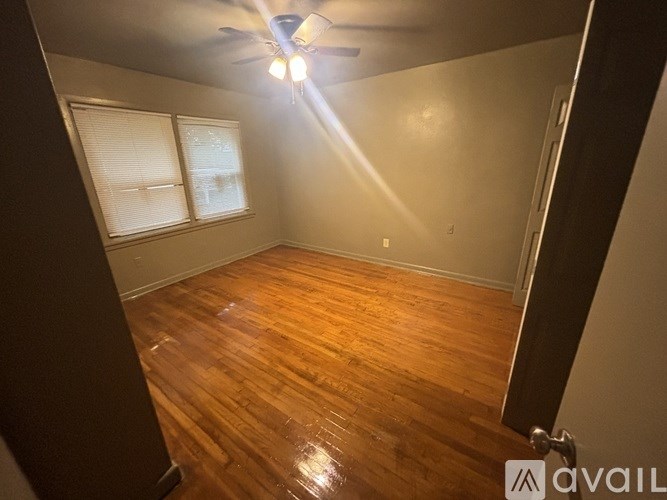 A room with wooden flooring and a ceiling fan.