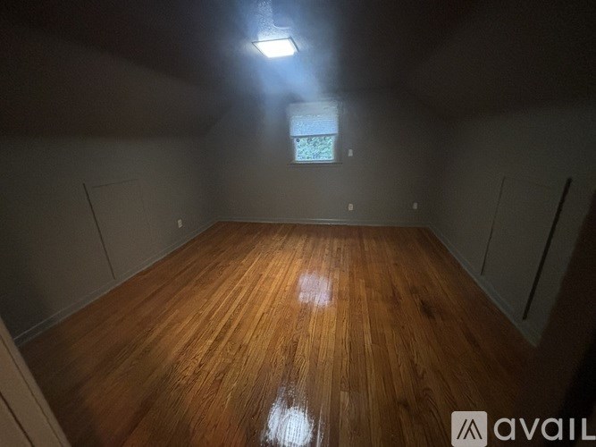 A room with wooden flooring and a window.