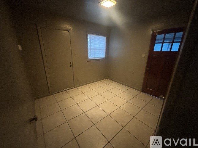 A room with a tiled floor and a window with blinds.