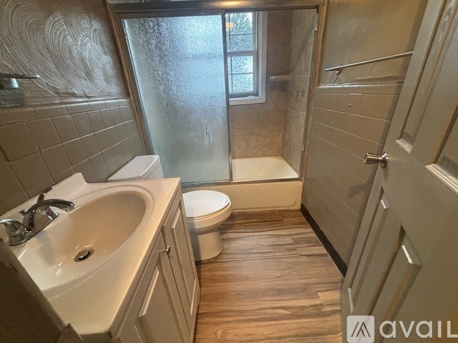 A bathroom with a toilet, sink, and shower.