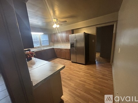 A kitchen with wooden floors and a refrigerator.
