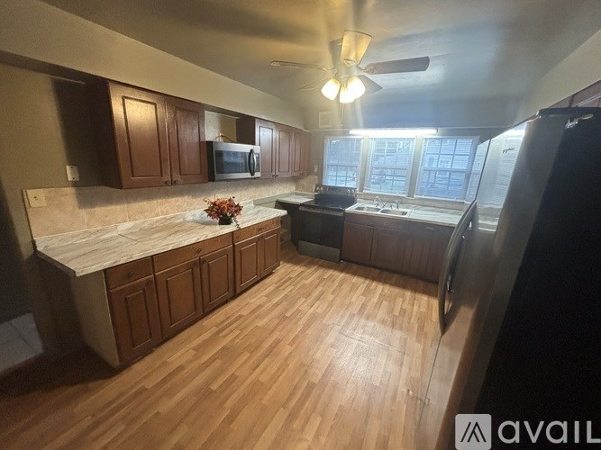 A kitchen with wooden floors and a marble countertop.