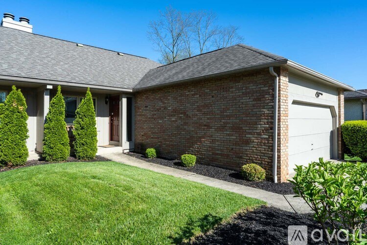 A house with a grey roof and a white garage door.