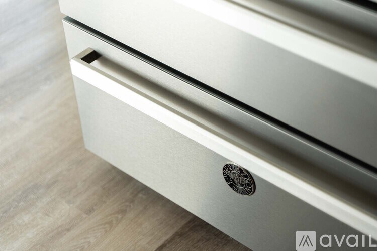 A close-up of a drawer with a handle and a logo on it.