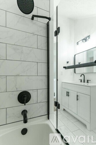 A white bathroom with a black shower head and faucet.