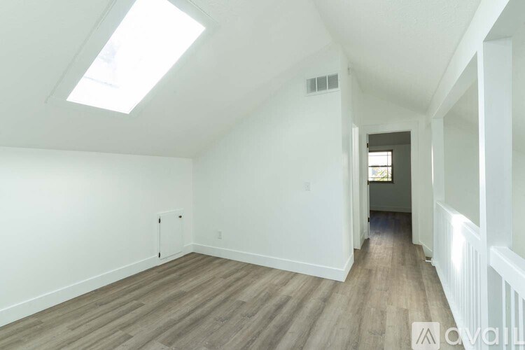 A room with wooden flooring and white walls.