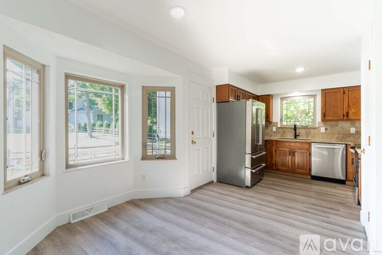 A kitchen with wooden cabinets and a refrigerator.