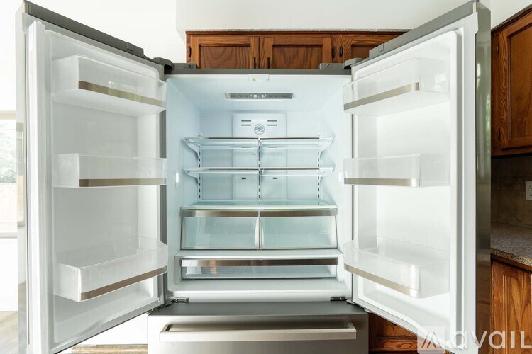 A white refrigerator with its door open in a kitchen.