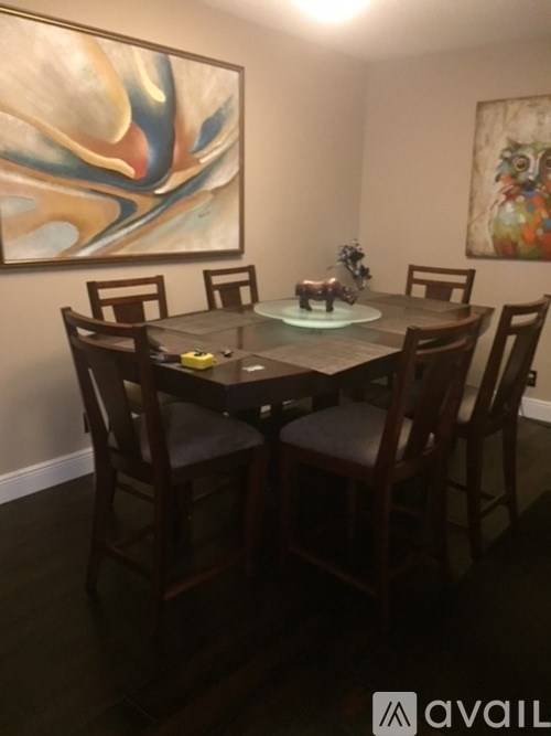 A dining room with a table and chairs.