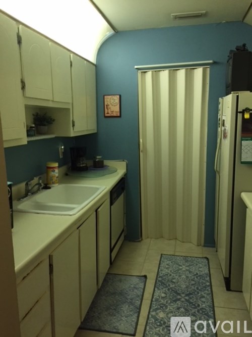 A kitchen with blue walls and white cabinets.