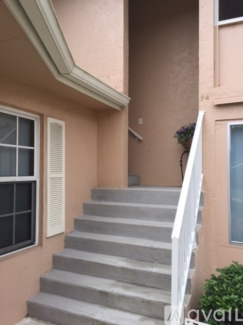 A staircase with a white railing leads up to a door.
