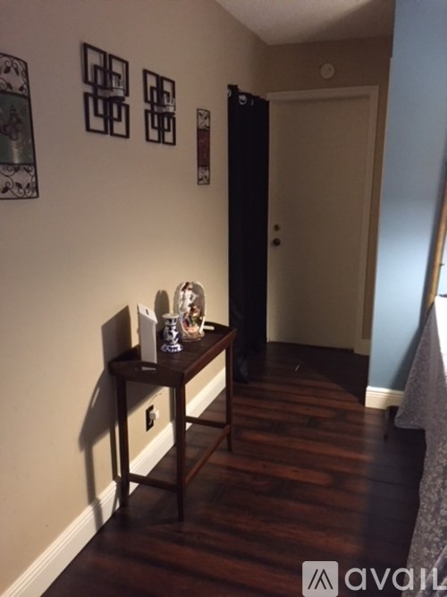 A hallway with a table and chairs on the left and a door on the right.