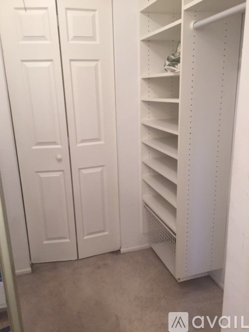A white closet with shelves and doors.
