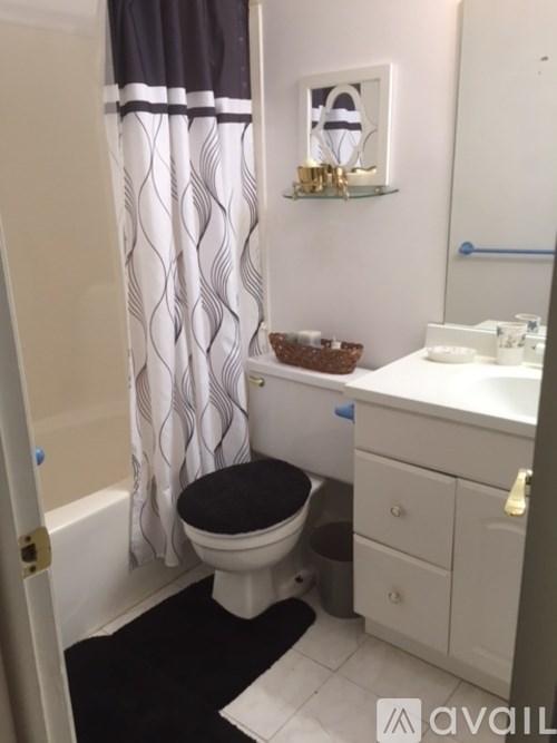 A bathroom with a toilet, sink, and shower curtain.