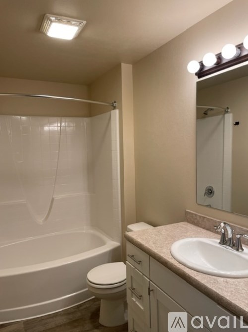 A bathroom with a white tub, sink, and toilet.