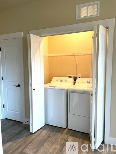 A white laundry room with a washer and dryer.