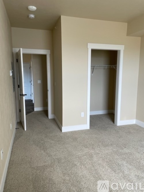 A room with a carpeted floor and a doorway leading to another room.