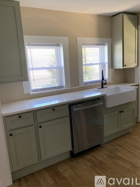 A kitchen with a sink, dishwasher and cabinets.