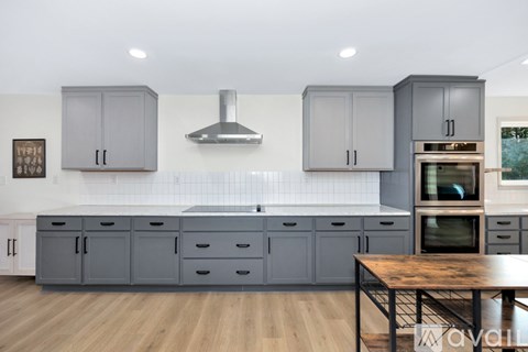A kitchen with grey cabinets and a wooden table.