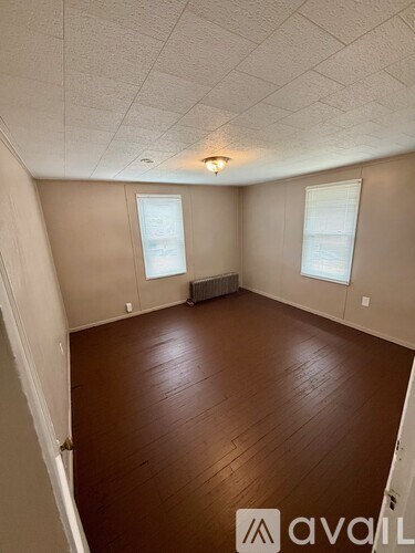 A living room with a sofa, chairs, and pictures on the wall.
