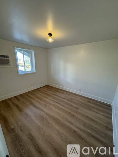 A room with wooden flooring and a window.