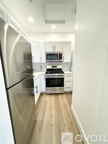 A kitchen with white cabinets and stainless steel appliances.