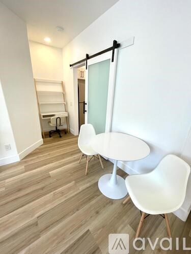 A room with a white table and chairs and a ladder.