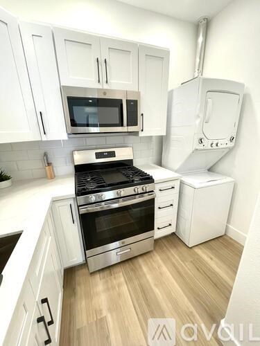 A kitchen with a stove, oven, microwave, and cabinetry.