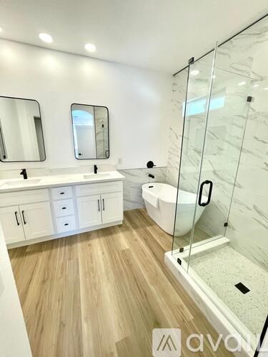 A modern bathroom with a glass shower stall and a white sink vanity.