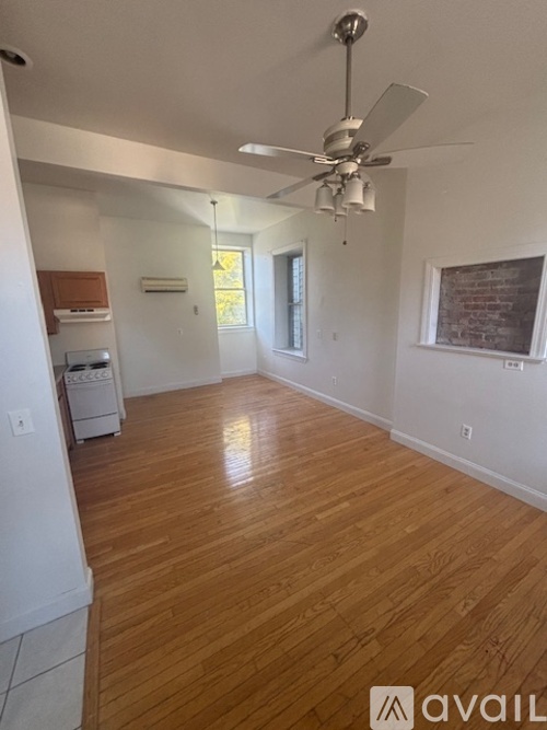A room with wooden flooring and a ceiling fan.