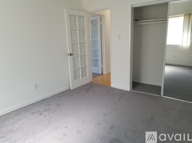 A room with a carpeted floor and a white door.