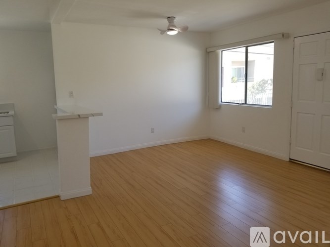 A room with wooden flooring and a window with blinds.