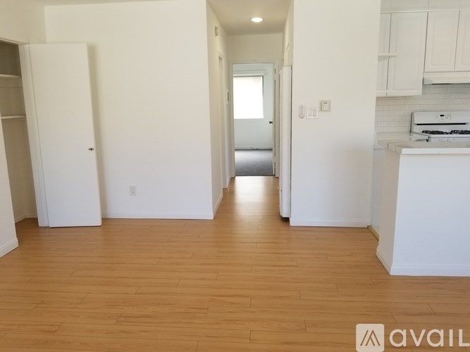 A kitchen area with a refrigerator, a sink, and a countertop.