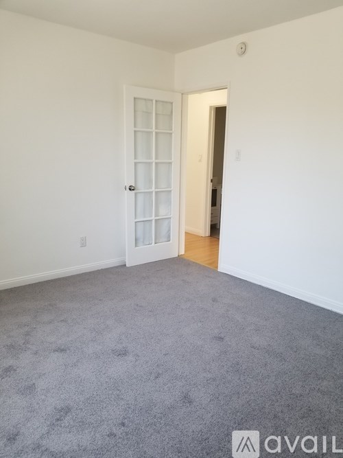 A room with a carpeted floor and a white door.