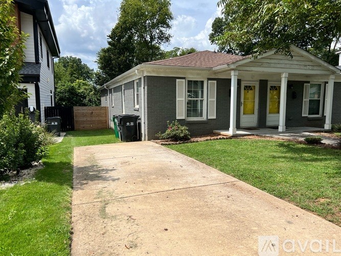 A small house with a porch and a yellow door.