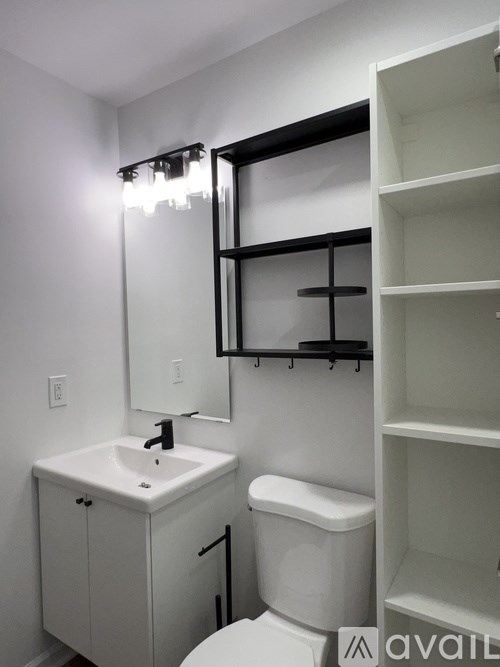 A bathroom with a white toilet, sink, and mirror.