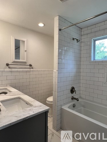 A bathroom with a white sink and a white tiled shower.