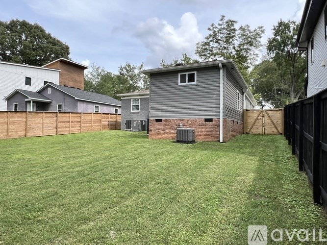 A backyard with a fence and a house in the background.