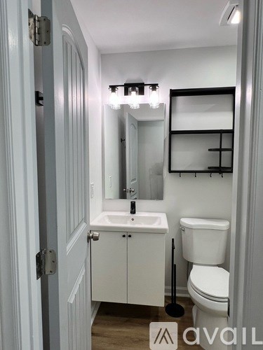 A bathroom with a sink, toilet and mirror.