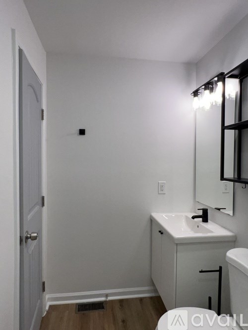 A bathroom with a white sink and a white cabinet.