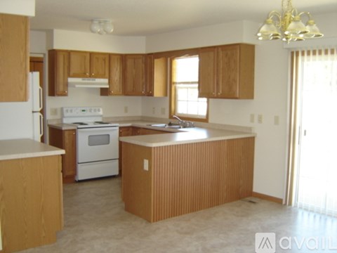 A kitchen with wooden cabinets and a white stove top oven.