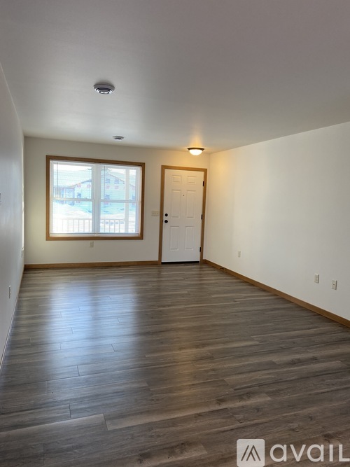 A room with wooden flooring and a window.