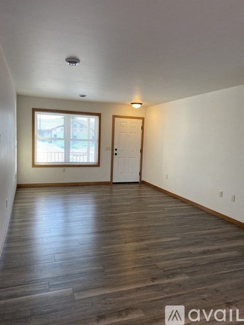A room with wooden flooring and a window.