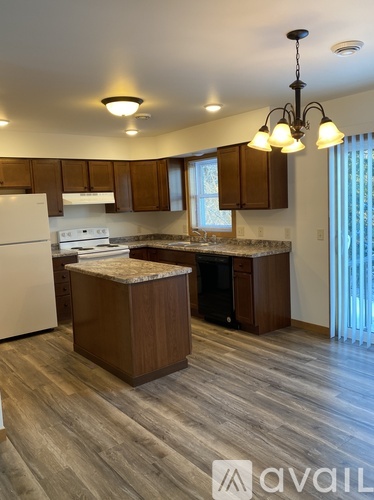 A kitchen with wooden cabinets and a white fridge.