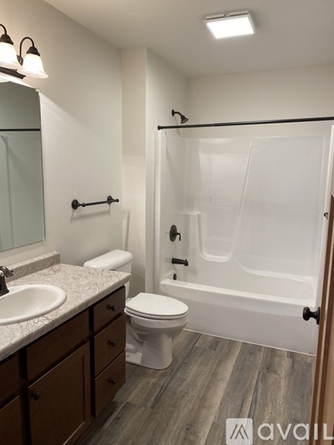 A bathroom with a toilet, sink, and bathtub.