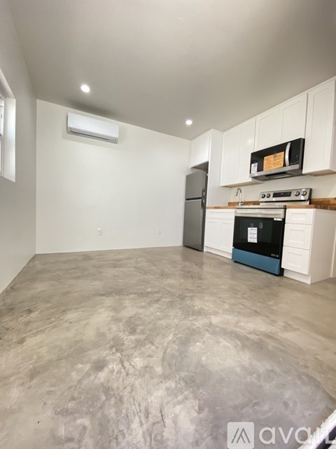 A kitchen with a refrigerator, oven, and microwave.