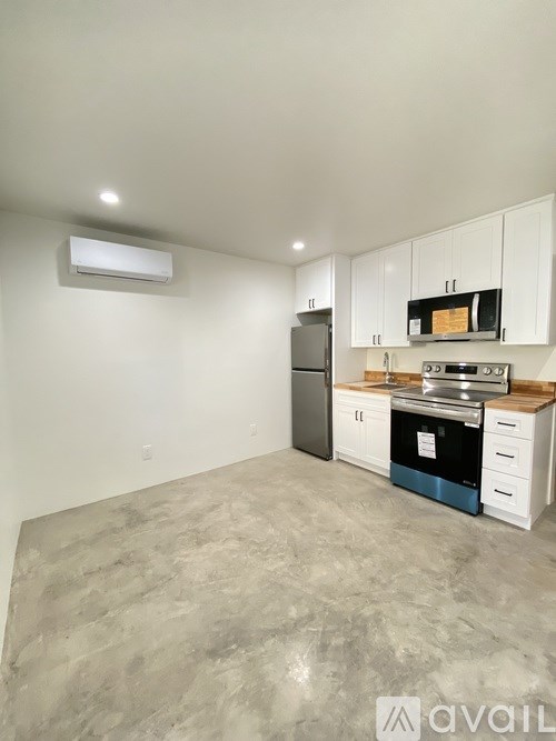 A kitchen with a refrigerator, oven, and microwave.