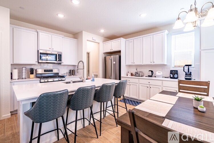 A kitchen with white cabinets and a wooden table.