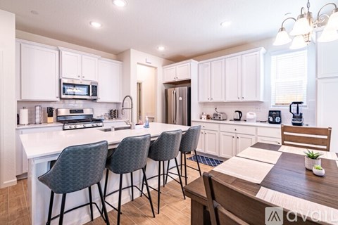 A kitchen with white cabinets and a wooden table.