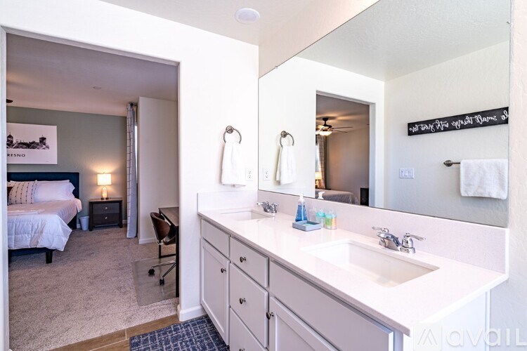 A bathroom with a white sink and a mirror above it.